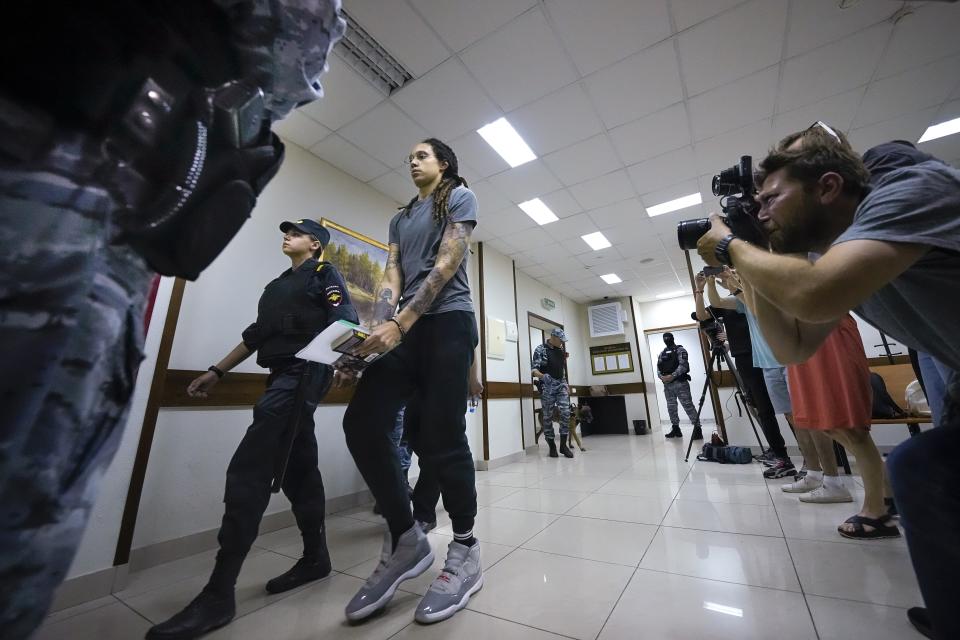 WNBA star and two-time Olympic gold medalist Brittney Griner is escorted from a court room ater a hearing, in Khimki just outside Moscow, Russia, Thursday, Aug. 4, 2022. A judge in Russia has convicted American basketball star Brittney Griner of drug possession and smuggling and sentenced her to nine years in prison. (AP Photo/Alexander Zemlianichenko)