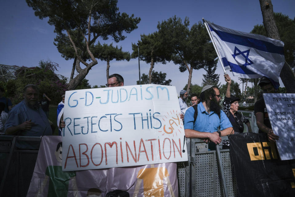 Israeli right-wing activists hold banners and wave the national flag, protesting against the annual Pride parade in Jerusalem, Thursday, June 1, 2023. The annual event is taking place this year under Israel's most right-wing government ever, stacked with openly homophobic members. The march in the conservative city is always tense and tightly secured by police and has been wracked by violence in the past. (AP Photo/Mahmoud Illean)