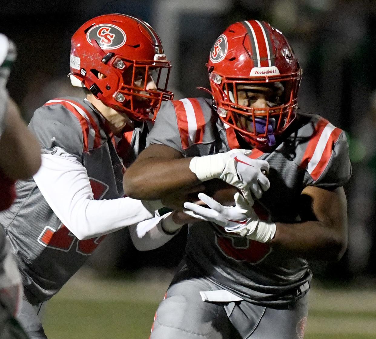 Canton South quarterback Poochie Snyder hands off the ball to running backs Rome Cox during the first half against West Branch in Division IV regional semifinal at Louisville Leopard Stadium. Friday, Nov. 10, 2023.