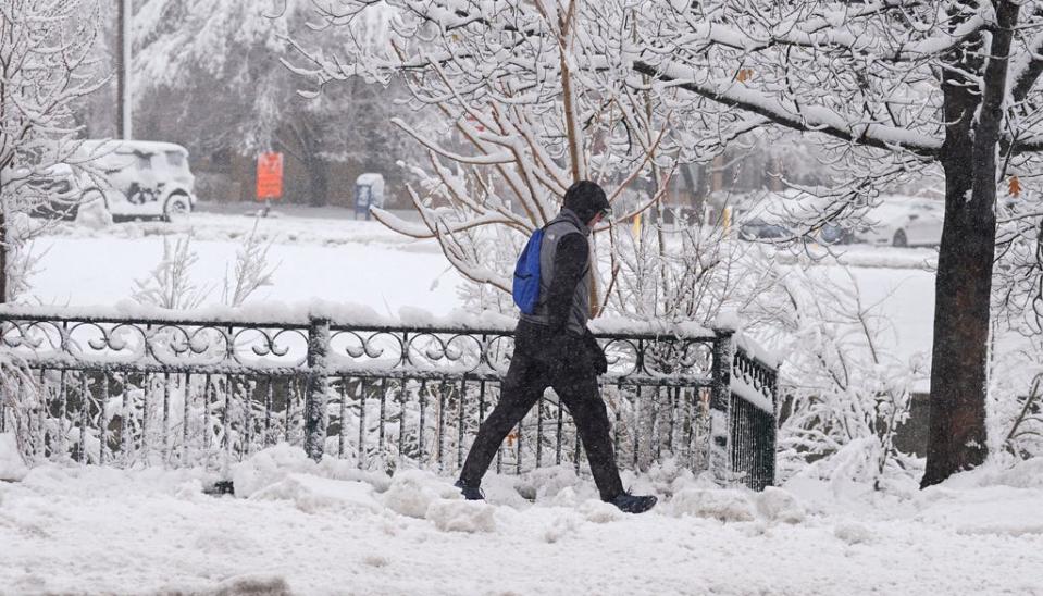 A pedestrian moves along Speer Boulevard as a late winter storm dropped up to a foot of snow Thursday, March 14, 2024, in Denver. Forecasters predict that the storm will persist until early Friday, snarling traffic along Colorado's Front Range communities.