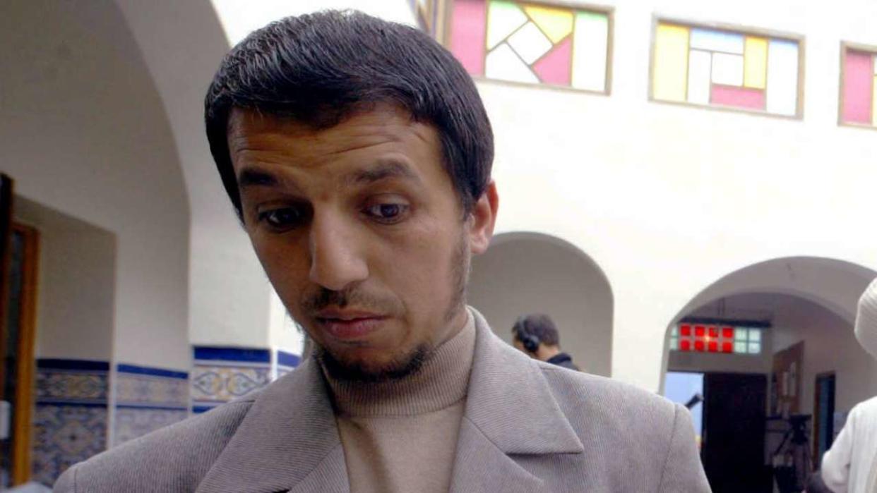 le président de l'association qui gère la mosquée d'Escaudain, près de Valenciennes, Hassan Iquioussen (G), aux côtés d'un prêcheur, montre le 18 juin 2004 une des balles tirée la nuit du 17 au 18 juin 2004 sur la porte de l'établissement religieux. (Photo by FRANCOIS LO PRESTI / AFP)