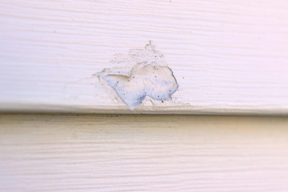 A bullet hole in vinyl siding has been repaired at Amy Shay's house in West Peoria.