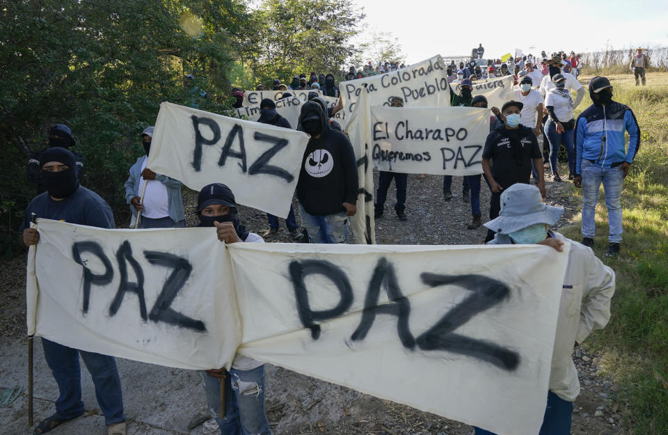 Residents of Aguililla and other nearby communities who are fed up with the army’s strategy of simply separating the Jalisco and the Michoacan-based Viagras gangs, march against roadblocks in Loma Blanca, Mexico, Tuesday, Nov. 16, 2021. The army policy effectively allows the Viagras, best known for kidnapping and extorting money, to set up roadblocks and checkpoints that have choked off all commerce with Aguililla. Limes and cattle heading out, or supplies heading in, must pay a war tax to the Viagras. (AP Photo/Eduardo Verdugo)