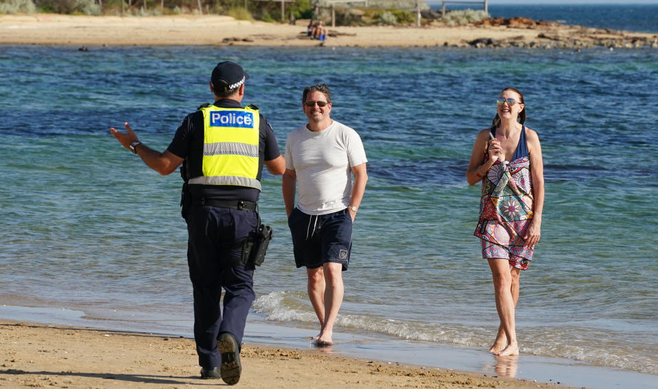 Police officers inform beachgoers that the beach is closed at Brighton Beach in Melbourne. Source: AAP