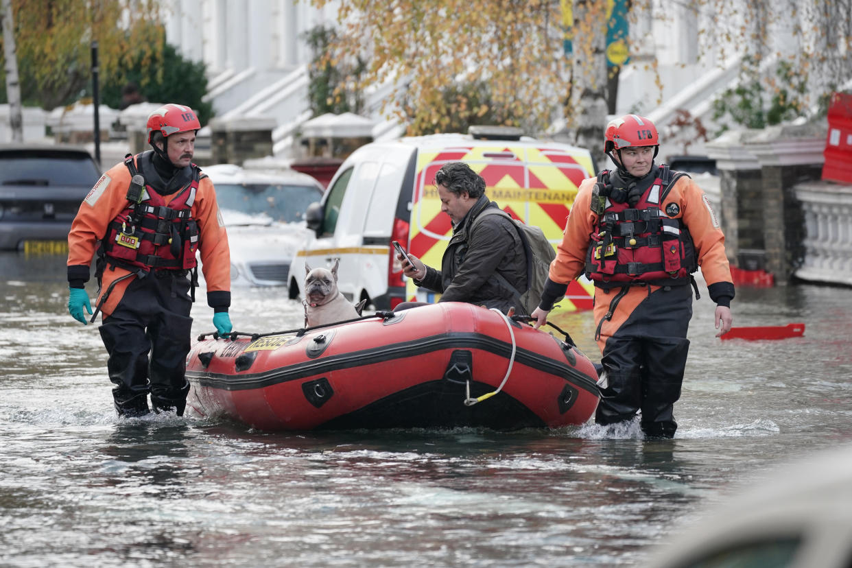 Emergency services rescue resident Stefano Calcagni and his dogs Batista and Pandora on Belsize Road in Camden after a burst water main flooded the London street. London Fire Brigade (LFB) said eight fire engines and around 60 firefighters were called to Belsize Road at 2.50am on Saturday morning after a 42-inch water main burst, causing flooding to a depth of half a metre across an area of around 800 metres. Picture date: Saturday December 17, 2022. (Photo by Yui Mok/PA Images via Getty Images)