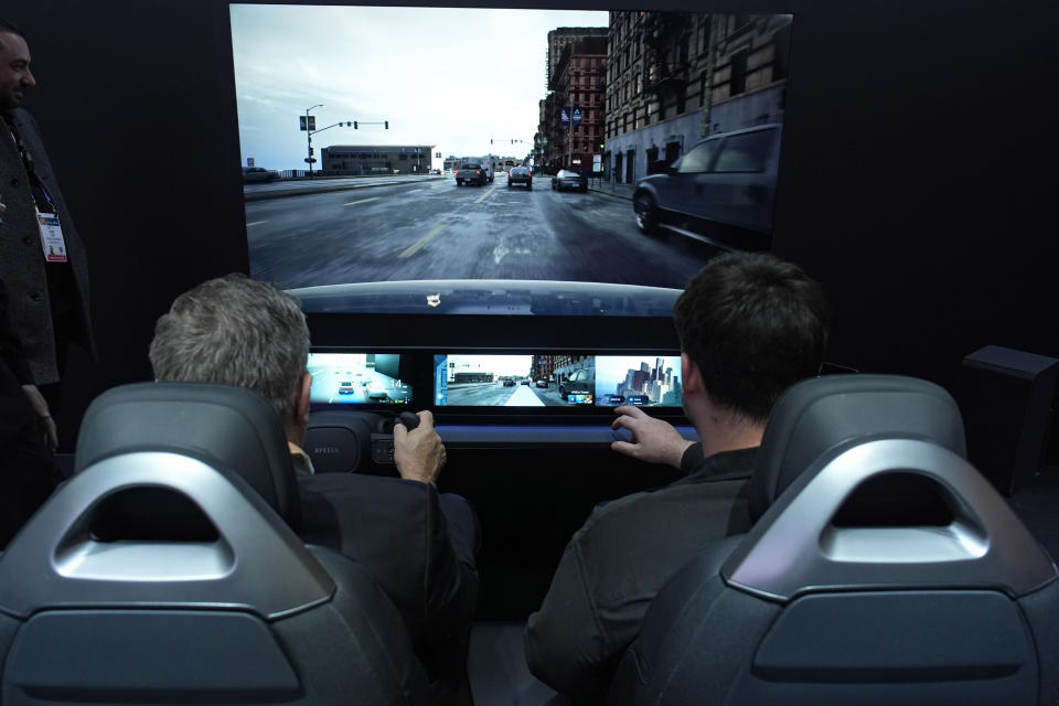 People sit in a Sony Honda Mobility Afeela EV simulator at the Sony booth during the CES tech show Tuesday, Jan. 9, 2024, in Las Vegas. (AP Photo/John Locher)