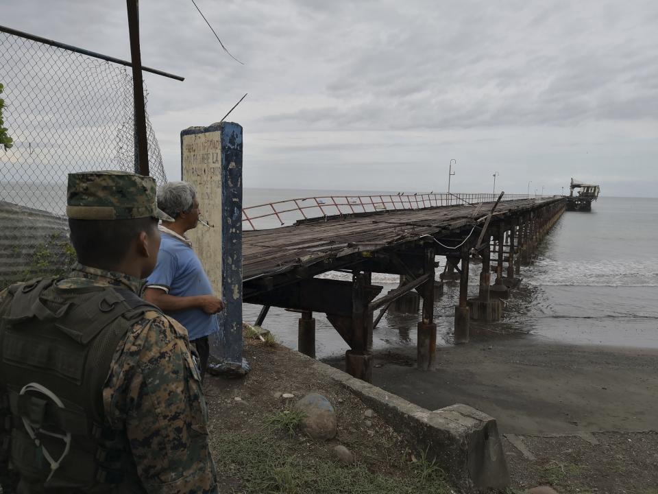 A police officer and resident look out at an abandoned pier after an earthquake made the office structure at the end incline to the right, in Puerto Armuelles, Sunday, May 12, 2019. Authorities had no reports of serious damage or injuries more than two hours after the 6.1 magnitude earthquake struck a lightly populated area of Panama near its border with Costa Rica. (AP Photo)