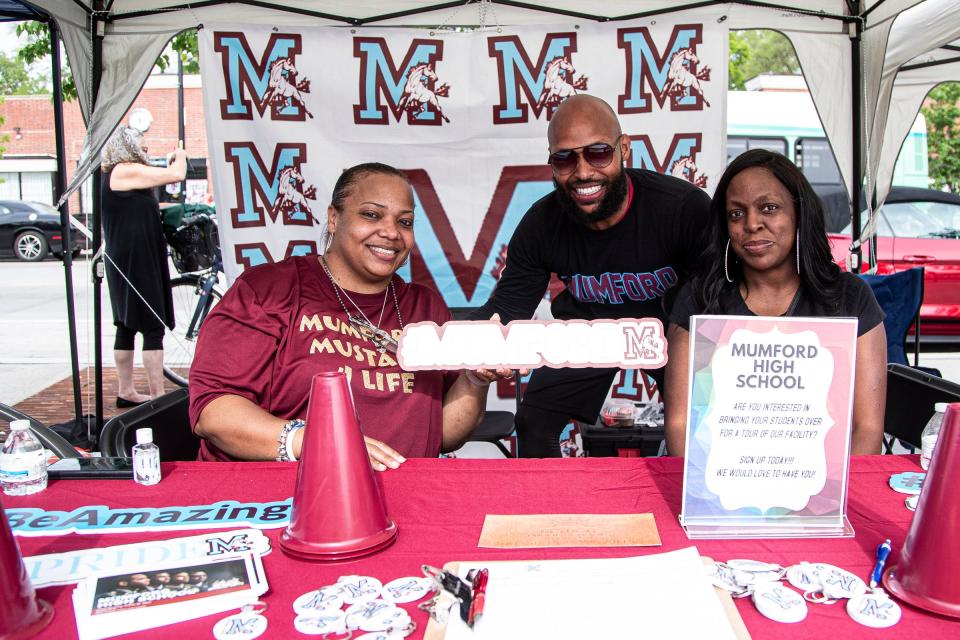 From left, Mumford High School's counselor N’Shan Robinson, principal Damon Pitt and math teacher Netyla Jones greet people at the Mumford tent on Livernois Avenue, during the Taste of Livernois as a part of Detroit Public Schools' Alumni Weekend in Detroit on Saturday, May 21, 2022.