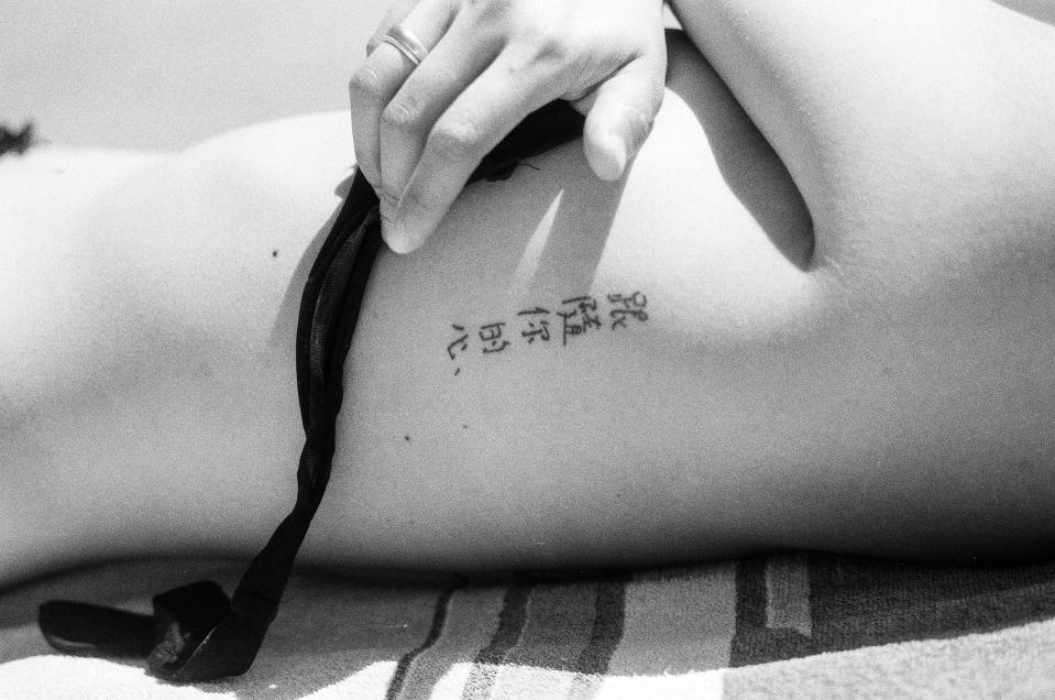 Person's ribs with a tattoo featuring Chinese characters