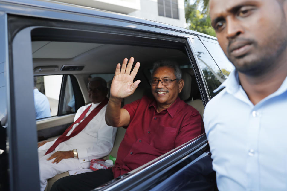 Sri Lanka's former Defense Secretary and president elect Gotabaya Rajapaksa in red, waves to supporters as he leaves the election commission after the announcement of his victory with elder brother Chamal, in white, in Colombo, Sri Lanka, Sunday, Nov.17, 2019. Rajapaksa, revered by Sri Lanka's ethnic majority for his role in ending a bloody civil war but feared by minorities for his brutal approach, declared victory Sunday in the nation's presidential election.(AP Photo/Eranga Jayawardena)