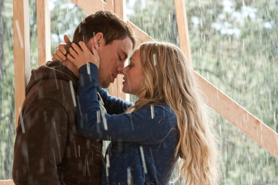 A man and a woman kiss in the rain