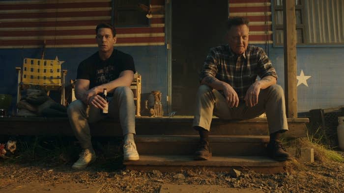 John Cena and Robert Patrick sitting outside Peacemaker's cabin