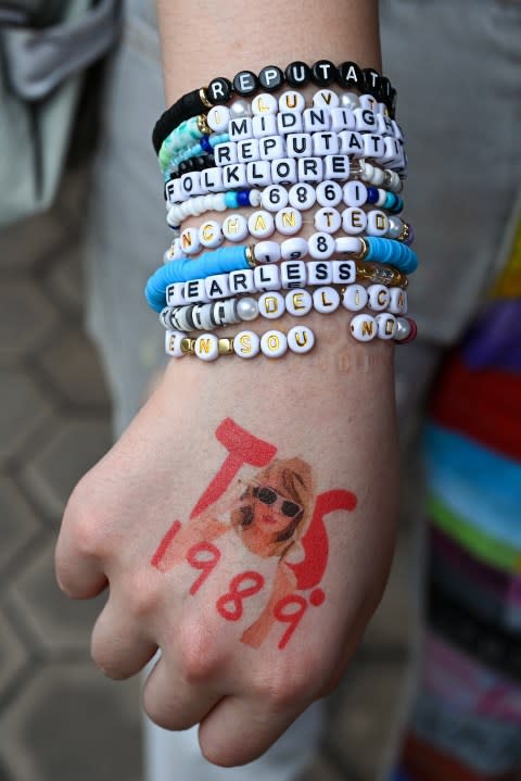 <sub><sup>A fan of US singer Taylor Swift, also known as a Swiftie, displays friendship bracelets as they arrive for the pop star’s Eras Tour concert at the National Stadium in Singapore on March 7, 2024. (Photo by Roslan RAHMAN / AFP) (Photo by ROSLAN RAHMAN/AFP via Getty Images)</sup></sub>