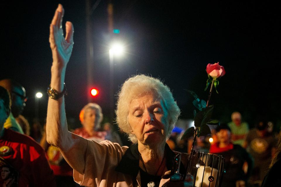 Jerry Engelby, from Jefferson City, Missouri, holds a rose and a candle as she sings along to “Can’t Help Falling in Love” in front of Graceland during the “Candlelight Vigil” as part of Elvis Week 2023 in Memphis, Tenn., on Tuesday, August 15, 2023. “It comes to me every year,” Engelby said about the song. “Can’t help falling in love with him over and over and over at the age I am with grandkids.”