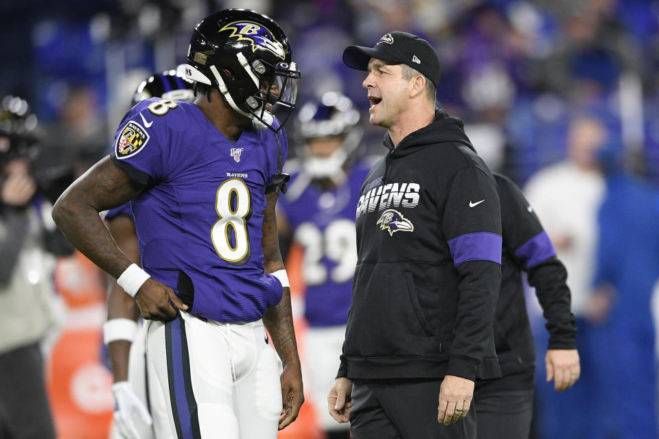 Baltimore Ravens quarterback Lamar Jackson (8) speaks with coach John Harbaugh before an NFL divisional playoff football game against the Tennessee Titans. (AP Photo/Nick Wass)