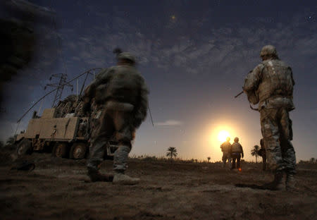 FILE PHOTO: U.S. Army soldiers from Charlie Company 2-5 Cavalry Regiment watch illumination rounds during a night patrol near Camp Kalsu in Tunis, Iraq December 5, 2011. REUTERS/Shannon Stapleton/File Photo