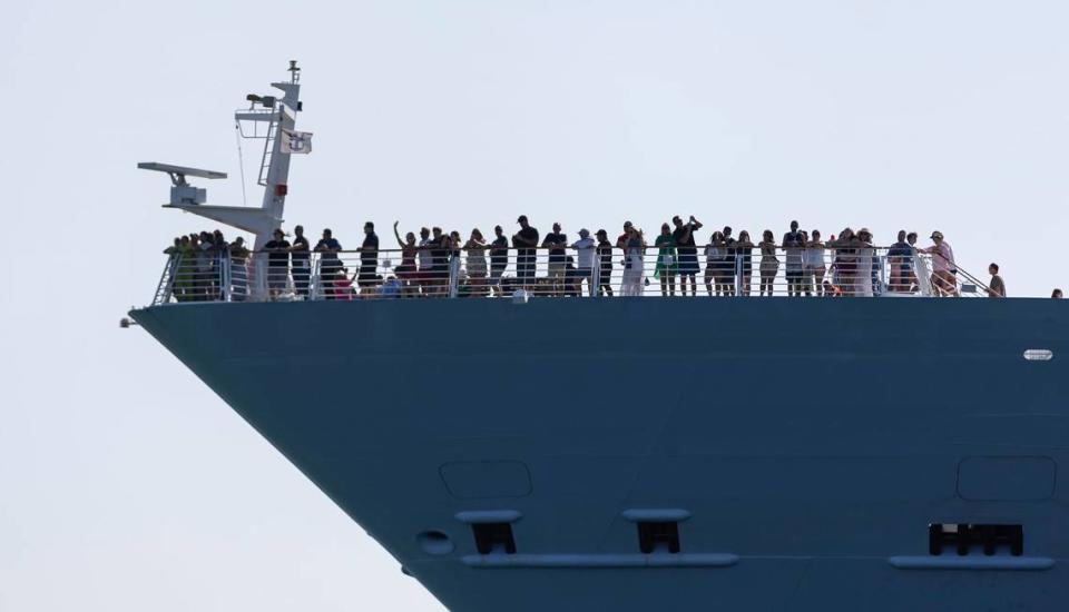 Passengers aboard Royal Caribbean’s Freedom of the Seas react as they leave PortMiami on Friday, April 12, 2024, in Miami, Fla.