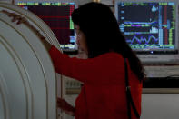 A woman checks stock prices at a brokerage house in Beijing, Thursday, Sept. 19, 2019. Shares were mixed in Asia on Thursday, with Tokyo and Sydney logging modest gains after the Federal Reserve cut its benchmark interest rate for a second time this year, citing slowing global economic growth and uncertainty over U.S. trade conflicts. (AP Photo/Andy Wong)