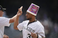 Colorado Rockies catcher Elias Diaz wears a gum container on his head after celebrating with teammates following pinch-hitter Charlie Blackmon's walkoff, RBI-single against the San Diego Padres in the ninth inning of a baseball game Wednesday, June 16, 2021, in Denver. The Rockies won 8-7 to sweep the three-game set. (AP Photo/David Zalubowski)