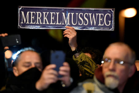 Protesters demonstrate during a visit of German Chancellor Angela Merkel in Chemnitz, Germany November 16, 2018. The sign reads "Merkel must go". REUTERS/Matthias Rietschel