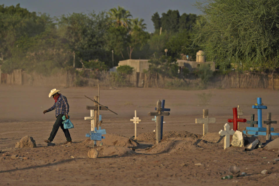 A Yaqui Indigenous man walks past the cemetery where slain water-defense leader Tomás Rojo is buried in Potam, Mexico, on Sept. 27, 2022. (Fernando Llano / AP)