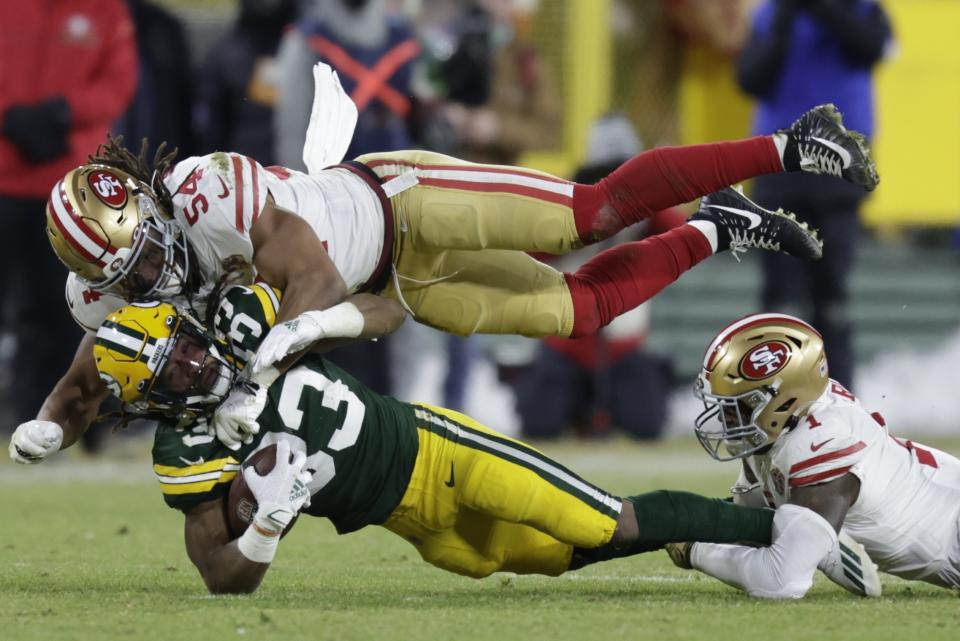 San Francisco 49ers' Fred Warner stops Green Bay Packers' Aaron Jones during the first half of an NFC divisional playoff NFL football game Saturday, Jan. 22, 2022, in Green Bay, Wis. (AP Photo/Matt Ludtke)