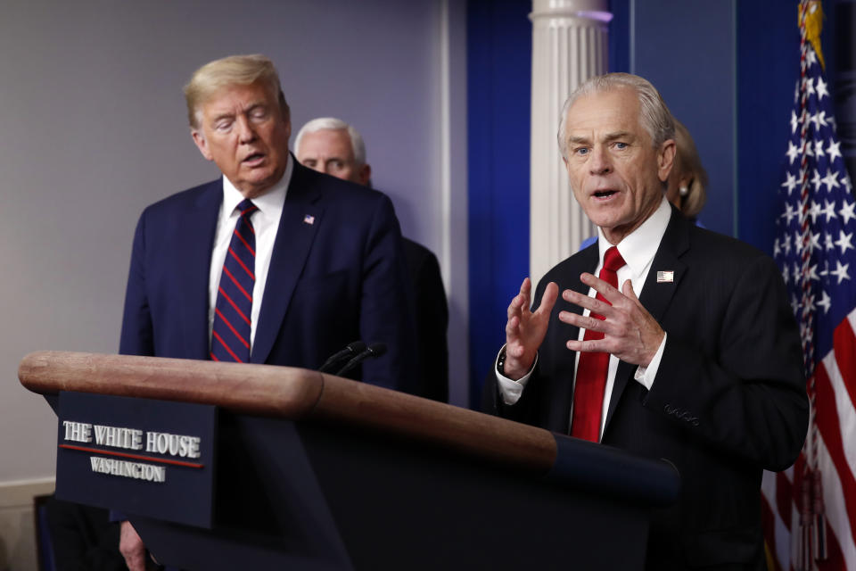 FILE - In this Friday, March 27, 2020 file photo, White House adviser Peter Navarro speaks about the coronavirus in the James Brady Press Briefing Room in Washington, as President Donald Trump listens. Navarro, Trump’s top assistant for trade and manufacturing policy, said in a March 19, 2020 email that he would soon be “flooding” the office of Dr. Robert Kadlec, whose job is to help guide the country through public health emergencies, with contracts for possible treatments. “Your shop is now officially a bottleneck,” Navarro told the assistant secretary for preparedness and response at the Department of Health and Human Services. (AP Photo/Alex Brandon)