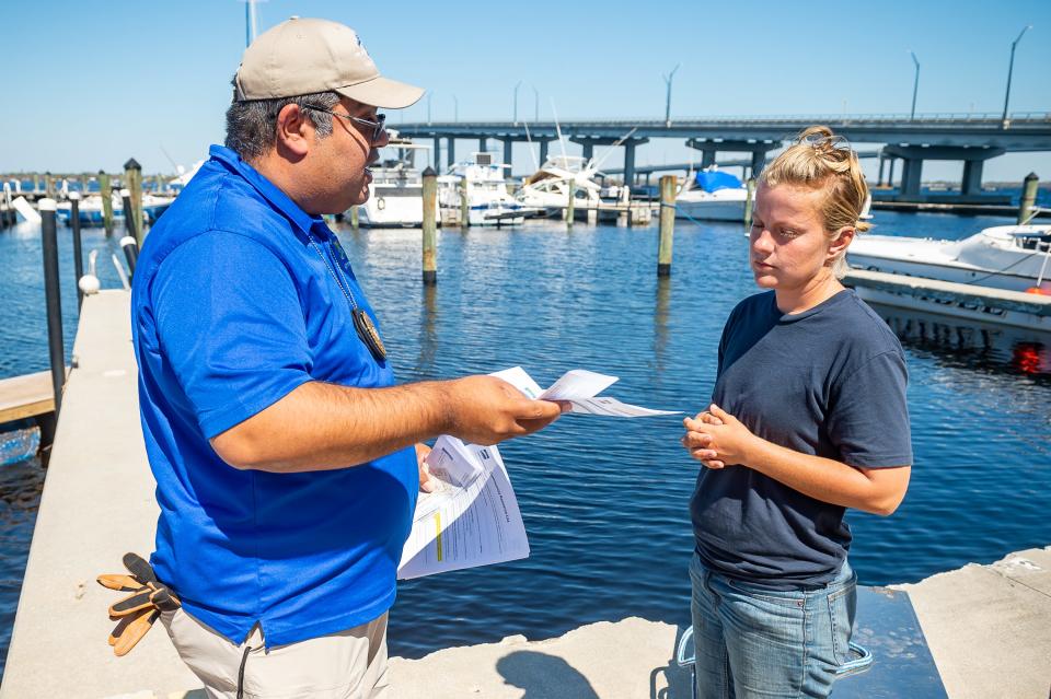 Ft Myers Police and Firefighters informing Lorelle Justice that all boat owners  they must leave the Ft Myers Yacht Basin, while residents are strongly opposed to leaving their boats. Friday, Oct. 7, 2022.