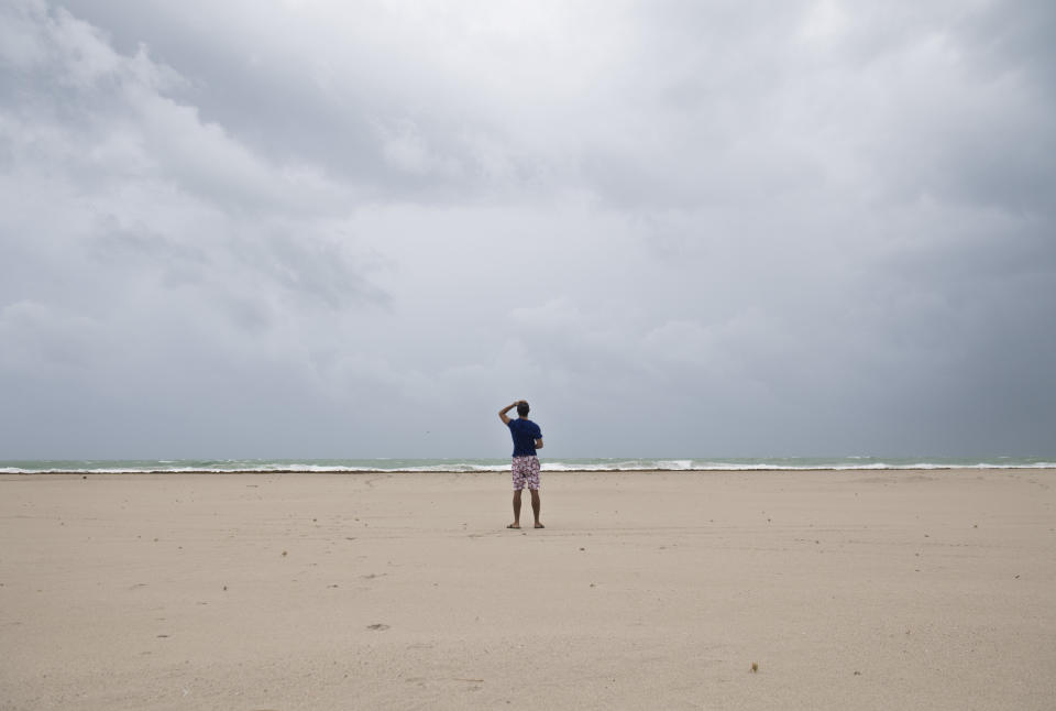 A man holds onto his hat as winds and rain begin to hit the beach as outer bands of Hurricane Irma arrive in Miami Beach, Florida, September 9, 2017. Hurricane Irma weakened slightly to a Category 4 storm early Saturday, according to the US National Hurricane Center, after making landfall hours earlier in Cuba with maximum-strength Category 5 winds. / AFP PHOTO / SAUL LOEB        (Photo credit should read SAUL LOEB/AFP/Getty Images)