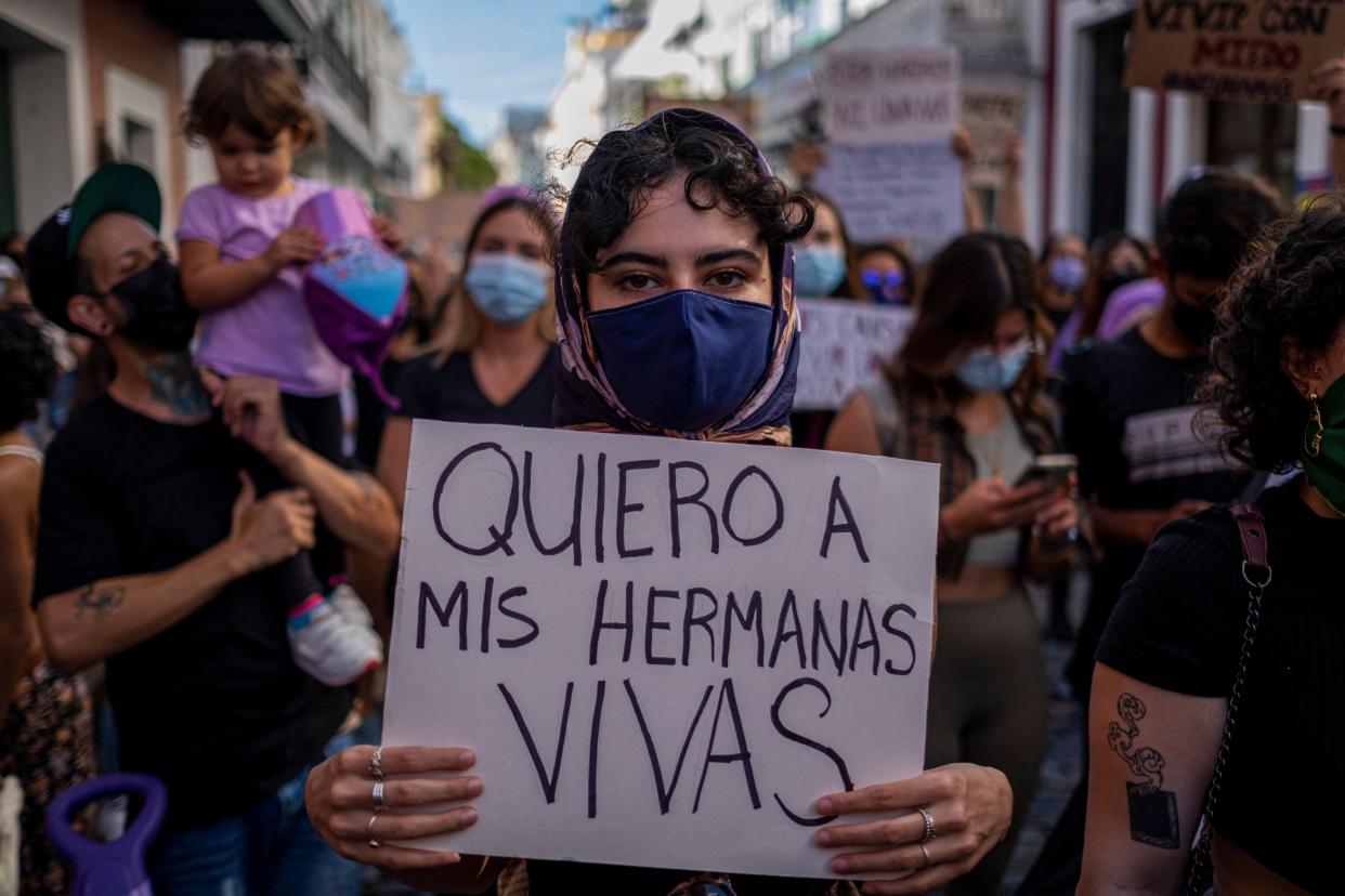 A woman member of a feminist collective holds a sign that reads in Spanish "I Want My Sisters Alive" during a demonstration against sexual violence in front of the governor's mansion in San Juan, Puerto Rico on May 3, 2021.