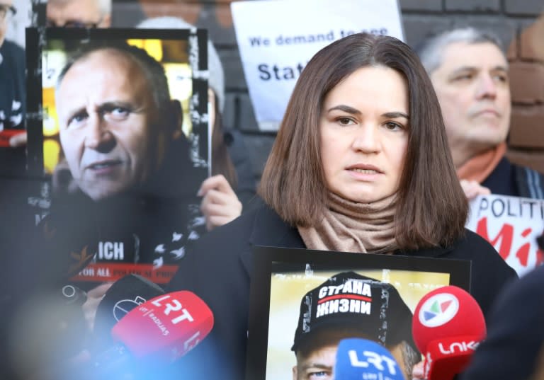 La líder de la oposición bielorrusa en el exilio, Svetlana Tijanóvskaya, sostiene un retrato de su encarcelado esposo, Serguéi Tijanovski, el 8 de marzo de 2024 frente a la embajada de Bielorrusia en Vilna (Petras Malukas)
