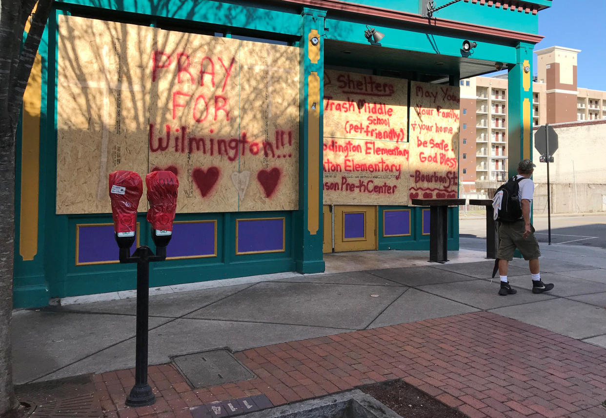 A man walks past boarded-up storefronts ahead of the arrival of Hurricane Florence in downtown Wilmington, North Carolina, U.S., Sept. 12, 2018 (Photo: Ernest Scheyder / Reuters)