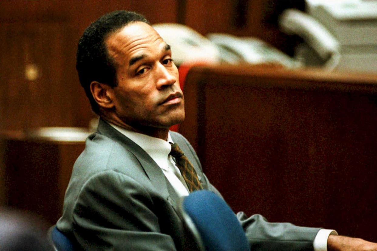 <span>OJ Simpson sits in court in Los Angeles on 8 December 1994. The trial provided one of the most-watched popular culture events of the last century.</span><span>Photograph: Pool via AFP - Getty Images</span>