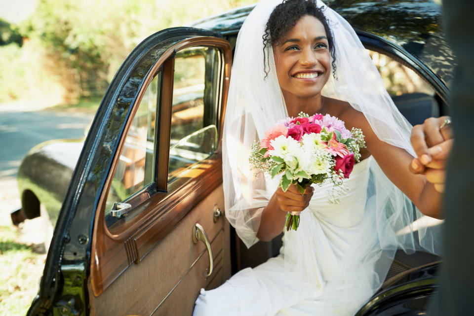 A bride being escorted from a car