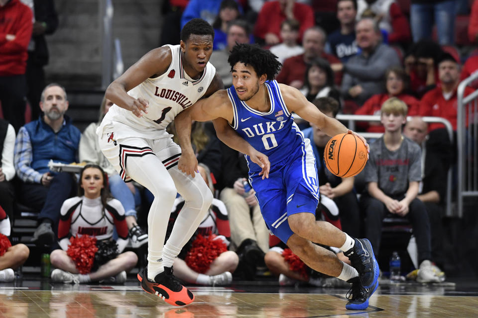 Duke guard Jared McCain (0) attempts to drive past Louisville guard Curtis Williams (1) during the second half of an NCAA college basketball game in Louisville, Ky., Tuesday, Jan. 23, 2024. Duke won 83-69. (AP Photo/Timothy D. Easley)