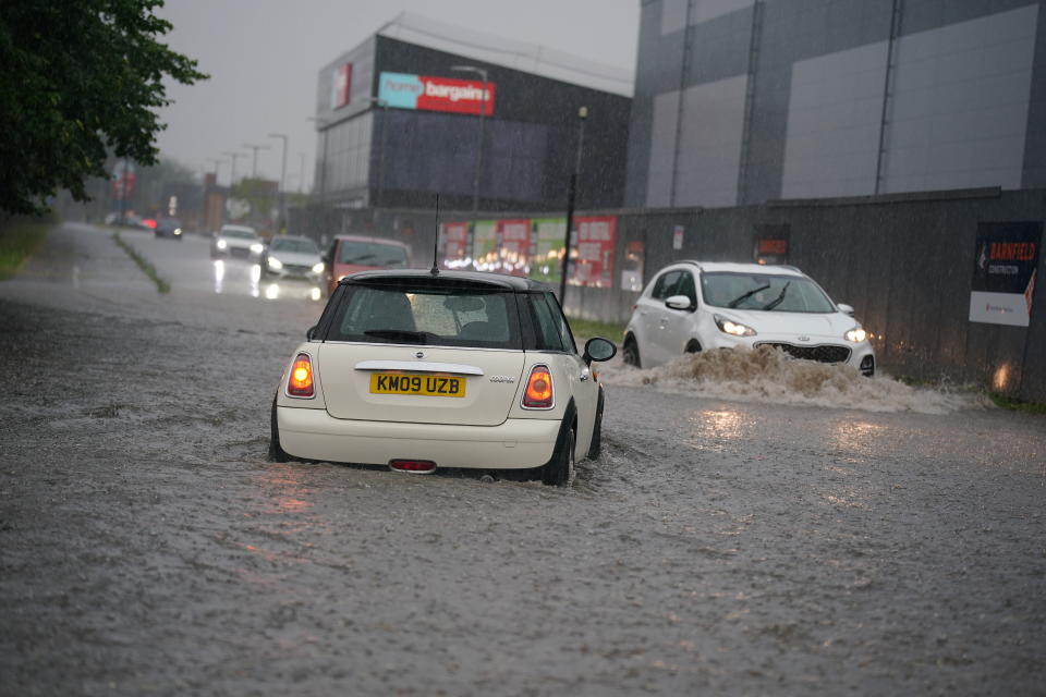 Cars drive through a flooded road after heavy rain in Speke, Liverpool. Picture date: Saturday July 8, 2023. The UK is facing thunderstorms and heavy rain as forecasts that the country could see the hottest of the year were changed. (Photo by Peter Byrne/PA Images via Getty Images)