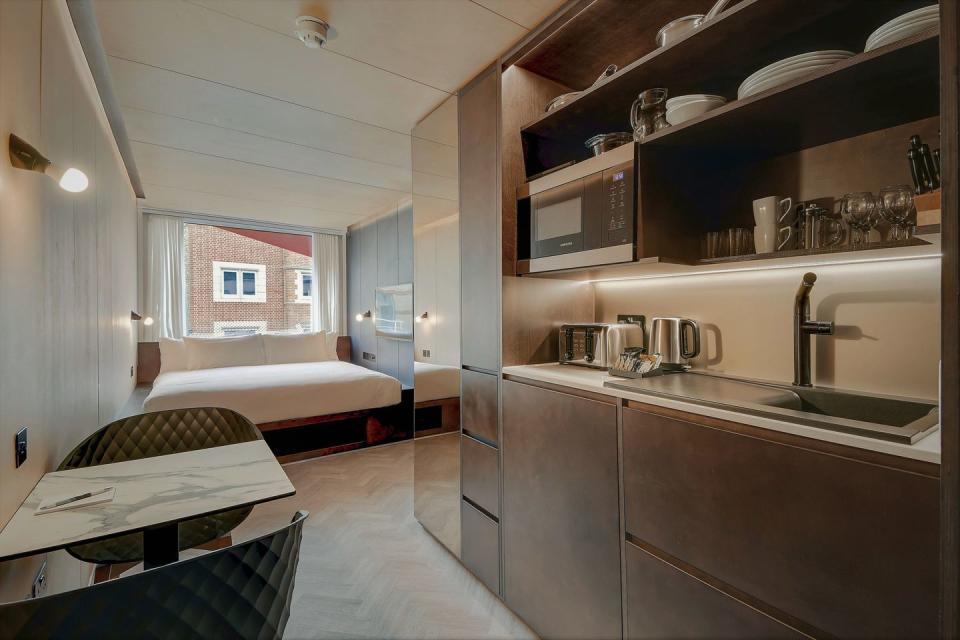 <p>Designed by firm Doone Silver Kerr, Stow-Away Waterloo is an apartment/hotel in London with 20 suites, each in its own refurbished shipping container. While the exterior features a stark white metallic façade, the interiors are crafted with warm woods.</p>
