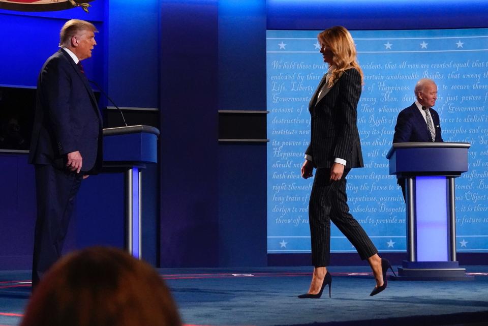 In this Sept. 29, 2020, file photo, President Donald Trump, left, watches as first lady Melania Trump, center, walks on stage past Democratic presidential candidate former Vice President Joe Biden, right, at the conclusion of the first presidential debate at Case Western University and Cleveland Clinic, in Cleveland, Ohio. President Trump and first lady Melania Trump have tested positive for the coronavirus, the president tweeted early Friday.