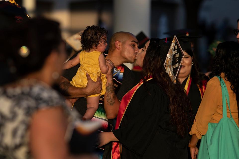 College of the Desert graduate Sergio Munoz, left, kisses his wife and fellow graduate Sarahy Sanchez while holding their 8-month-old daughter Saranhy Munoz-Sanchez before the commencement ceremony at the Indian Wells Tennis Garden in Indian Wells, Calif., on Wednesday, May 25, 2022. 