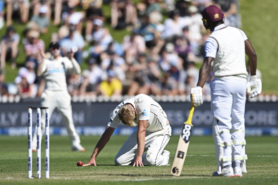 New Zealand's Kyle Jamieson, center, falls to his knees while bowling to the West Indies during play on the second day of their second cricket test at Basin Reserve in Wellington, New Zealand, Saturday, Dec. 12, 2020. (Andrew Cornaga/Photosport via AP)