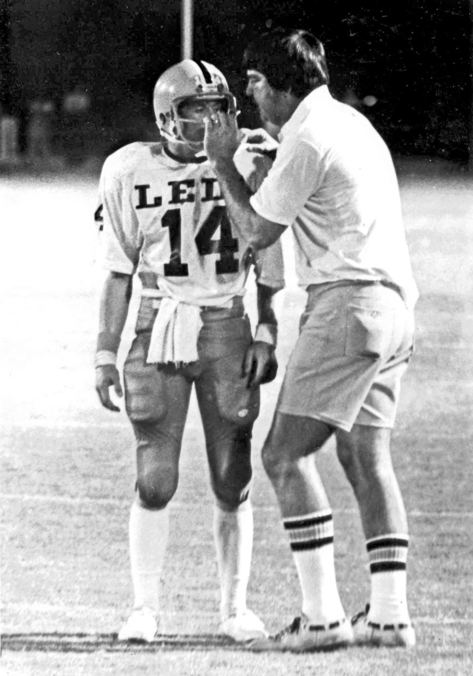 Lely Coach Bill "Bubba" Broxson grabs Rick Hansom's face mask as he sends in a play during the Trojans game against Naples in 1978.