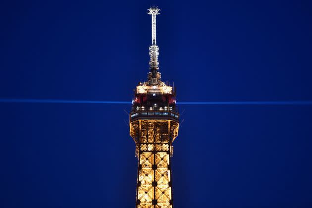 The top of the illuminated Eiffel Tower is pictured at night in Paris on March 8, 2021. (Photo: STEPHANE DE SAKUTIN/AFP via Getty Images)
