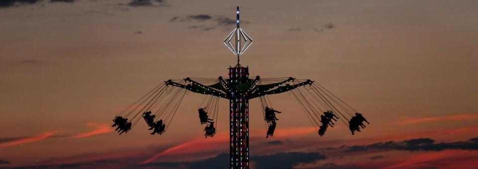 The wave swings in the dusk sky above the Monroe County Fair.