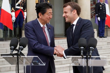 FILE PHOTO: French President Emmanuel Macron and Japan's Prime Minister Shinzo Abe give a joint statement to the media at the Elysee Palace in Paris