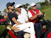 U.S. team member Dustin Johnson (C) rides on a golf cart with his fiance Paulina Gretzky (R) after he and teammate Jordan Spieth defeated International team's Danny Lee of New Zealand and Marc Leishman of Australia on the 15th hole during the opening foursome matches of the 2015 Presidents Cup golf tournament at the Jack Nicklaus Golf Club in Incheon, South Korea, October 8, 2015. REUTERS/Toru Hanai