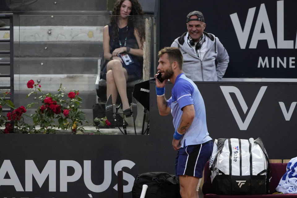 France's Corentin Moutet jokes with a cell phone during a match against Serbia's Novak Djokovic at the Italian Open tennis tournament in Rome, Friday, May 10, 2024. (AP Photo/Alessandra Tarantino)