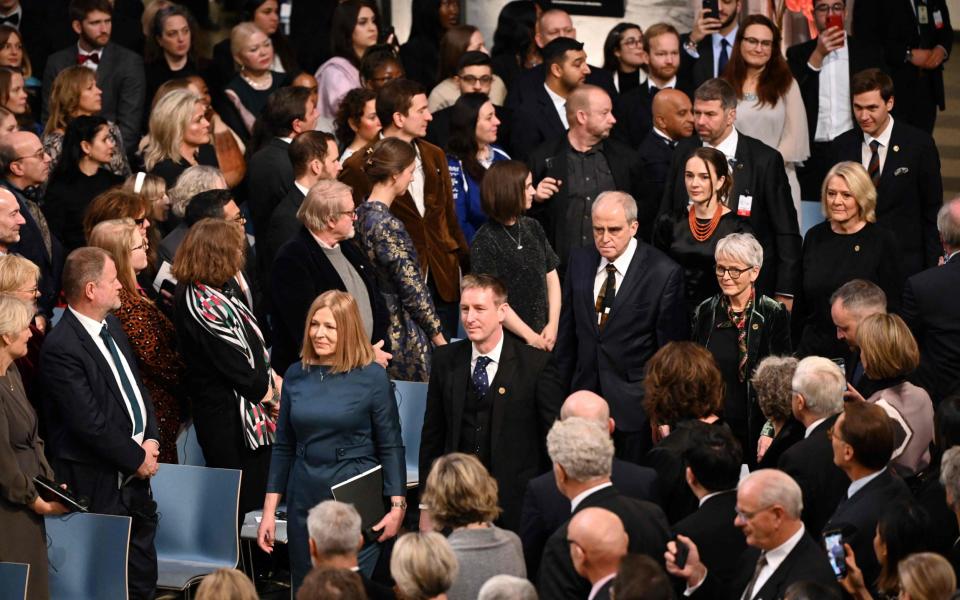 The three recipients walk down an aisle as the audience rises to their feet - SERGEI GAPON/AFP