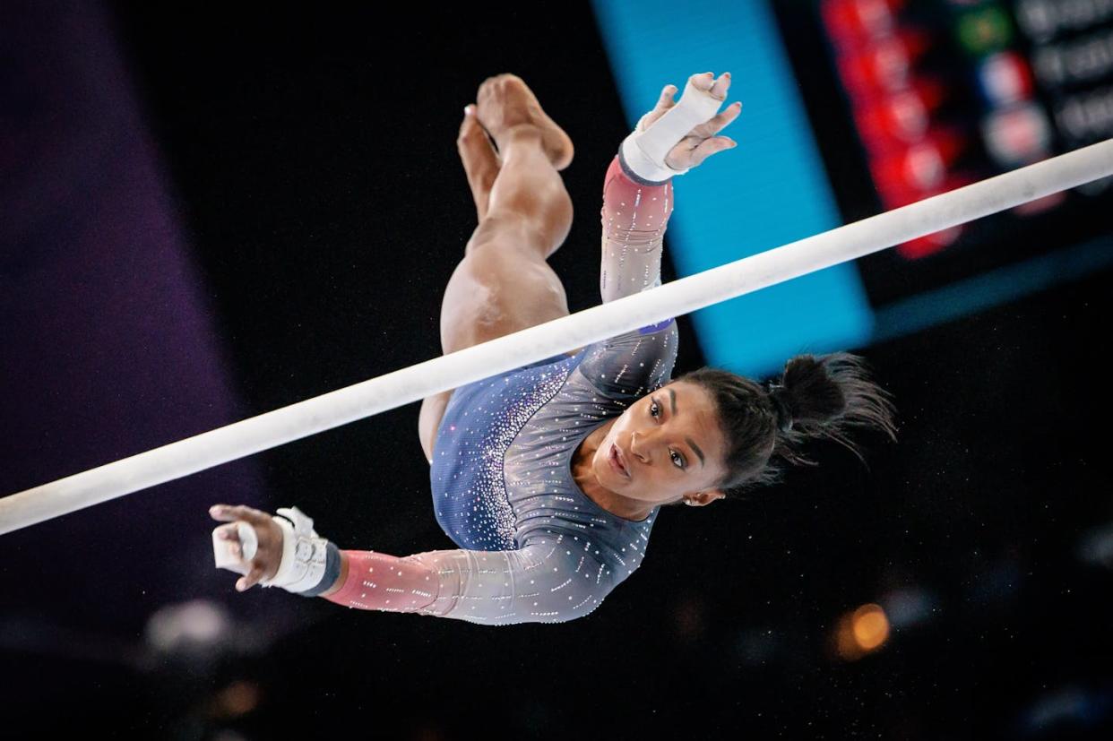 Simone Biles vuela sobre las barras asimétricas en los Mundiales de Gimnasia de Amberes en 2023. <a href="https://www.shutterstock.com/es/image-photo/antwerpen-belgium-october-04-2023-artistic-2371381713" rel="nofollow noopener" target="_blank" data-ylk="slk:Anders Riishede/Shutterstock;elm:context_link;itc:0;sec:content-canvas" class="link ">Anders Riishede/Shutterstock</a>