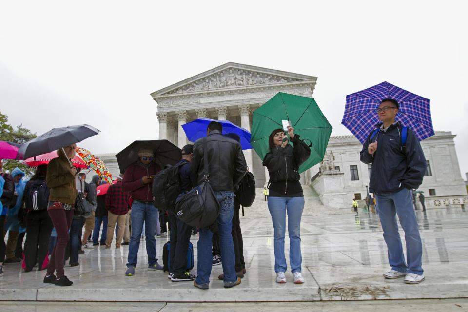 Olga Pavlovich take pictures with her cell phone as she lines up outside the Supreme Court in Washington, Tuesday, April 29, 2014, to listen to arguments. The Supreme Court is considering whether police may search cellphones found on people they arrest without first getting a warrant. ( AP Photo/Jose Luis Magana)