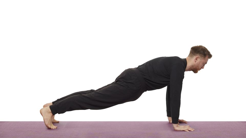 Yoga teacher Nick Higgins performs high plank pose
